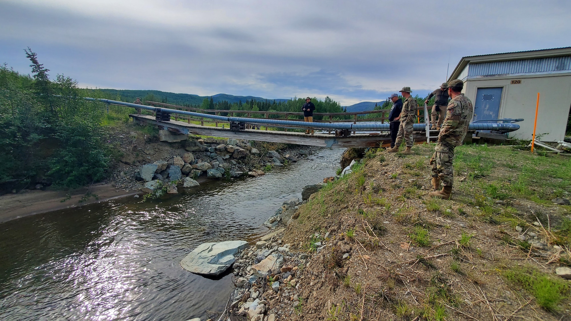 people stand near a bridge