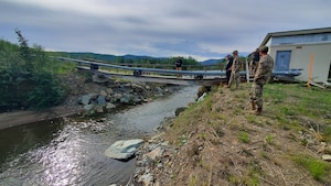 people stand near a bridge