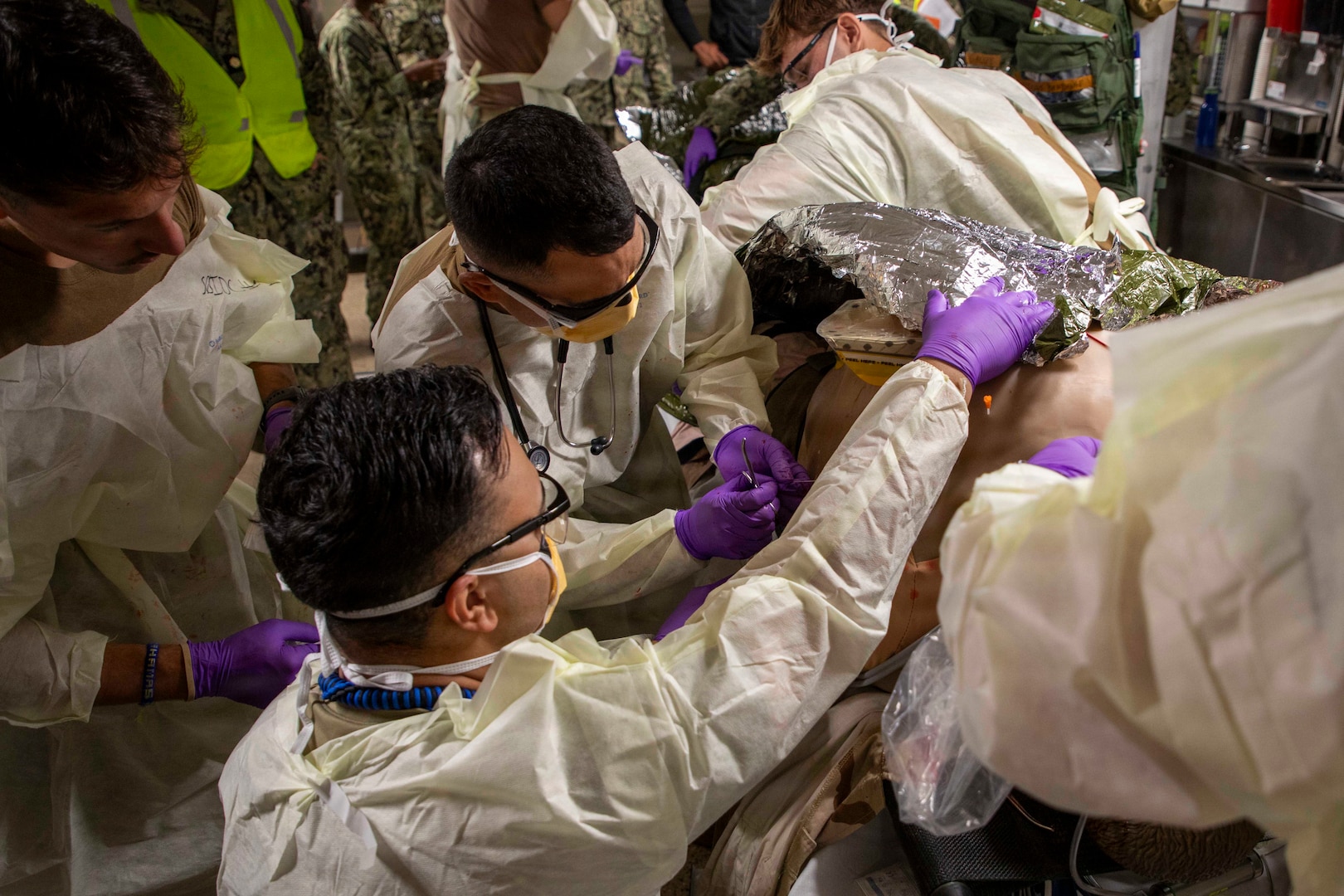 Sailors assigned to the Expeditionary Medical Unit (EMU-2) tie sutures on a medical dummy during an Operational Readiness Evaluation (ORE) aboard the expeditionary fast transport ship USNS Point Loma (T-EPF 15), July 25, 2026. The event marked the Navy’s first ORE conducted for an EMU, and the first afloat ORE for the Navy’s expeditionary medical capability, a critical step in validating deployable medical capabilities in support of maritime operations, distributed maritime operations, and warfighter readiness. (U.S. Navy photo by Mass Communication Specialist 1st Class Nathan T. Beard)