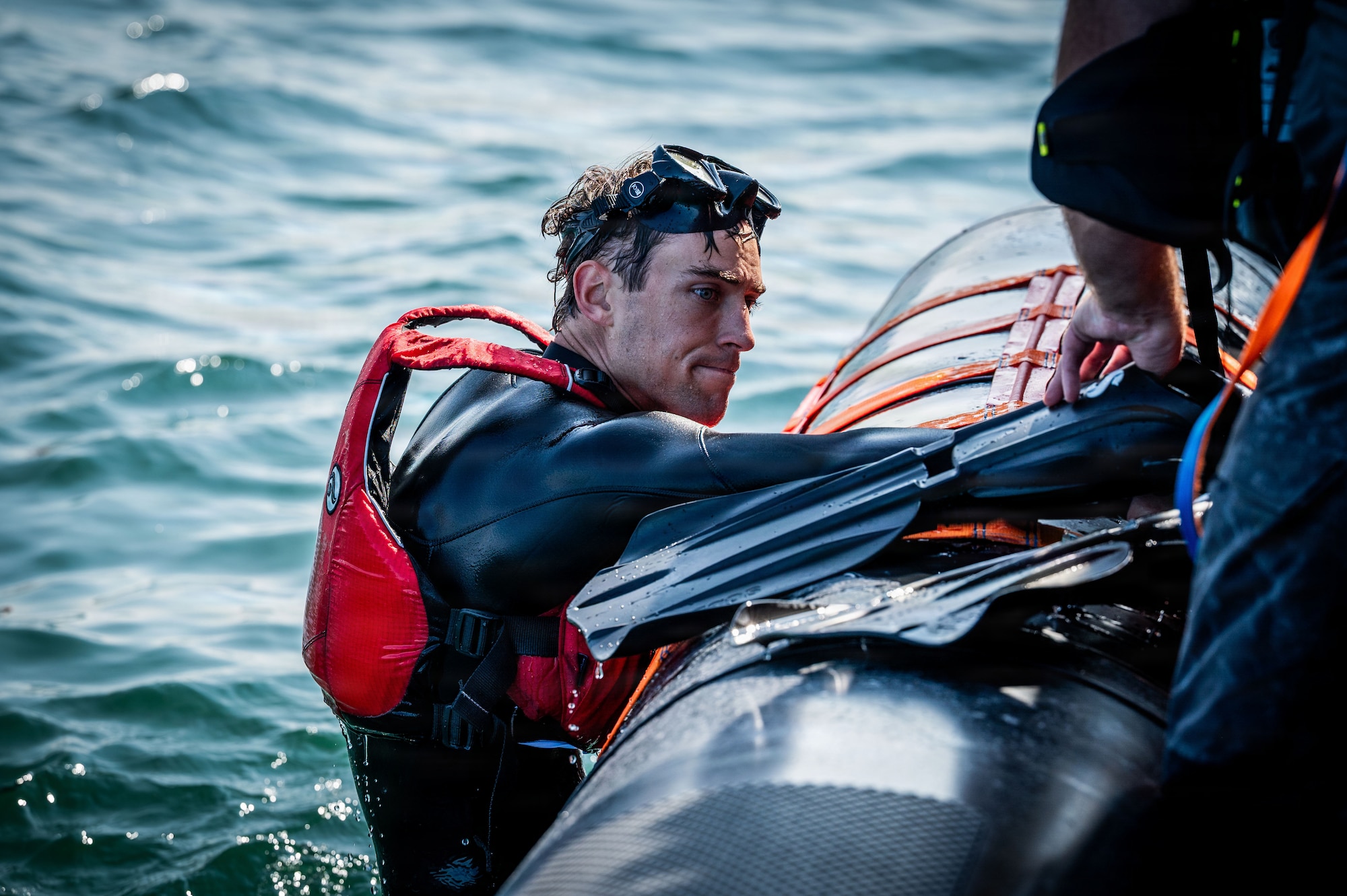 U.S. Air Force Staff Sgt. Wyatt Pooler, 100th Operational Support Squadron Survival, Evasion, Resistance, and Escape specialist, climbs into a Caister lifeboat during joint SERE training at Caister-on-Sea, England, July 23, 2026.