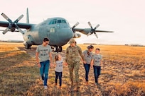 U.S. Air Force Staff Sgt. Brianna D. St. Lawrence-Brody poses with her four children in front of a Montana Air National Guard C-130H Hercules, 120th Airlift Wing in Great Falls, Montana.