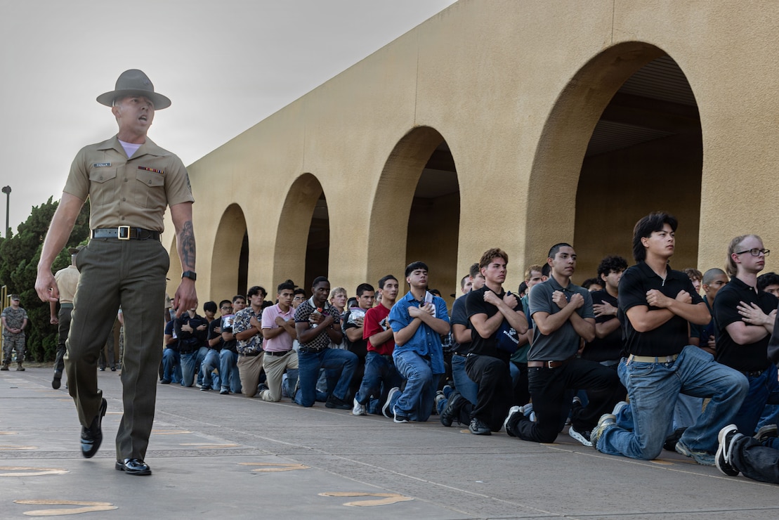 U.S. Marine Corps Sgt. Dominic Padilla, a drill instructor with Receiving Company, Support Battalion, gives a brief to recruits with Lima Company, 3rd Recruit Training Battalion during a receiving event at Marine Corps Recruit Depot San Diego, California, July 27, 2026. During the receiving process, recruits are inspected for contraband, make scripted phone calls home and receive haircuts to mark the beginning of the 13-week transformation to become United States Marines. (U.S. Marine Corps photo by Lance Cpl. Madeline Zane)
