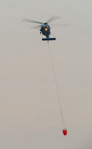 An Oregon Army National Guard HH-60M Black Hawk helicopter returns to Army Aviation Support Facility #2 in Pendleton, Oregon, carrying a water bucket, July 29, 2026, in support of wildland firefighting operations on the Hagen Fire in Umatilla County.