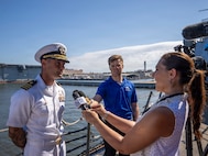 NORFOLK, Va. (July 31, 2026) — U.S. Navy Cmdr. Taylor Auclair, commanding officer of the Arleigh Burke-class guided-missile destroyer USS Truxtun (DDG 103) speaks with local media on Norfolk, July 31, 2026. The ship's return concludes a six-month deployment across multiple geographic theaters, including the U.S. 4th, 5th and 6th Fleet areas of operations. (U.S. Navy photo by Mass Communication Specialist 2nd Class Justin McTaggart)