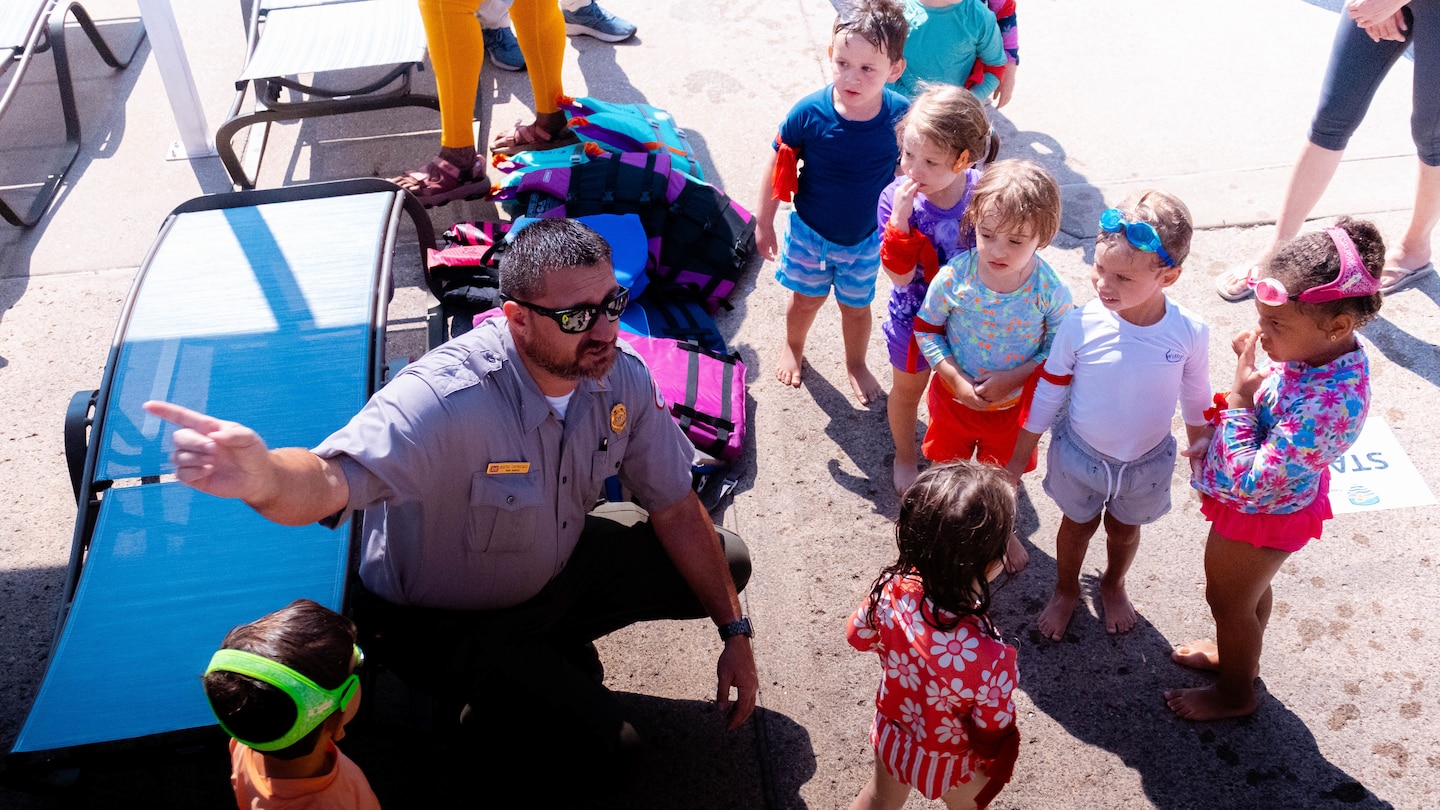 Park Ranger Dustin Enstrocaso demonstrates life jacket safety to a small group of children during the Largest Swimming Lesson event on June 23, 2026 in Nashville, Tenn.