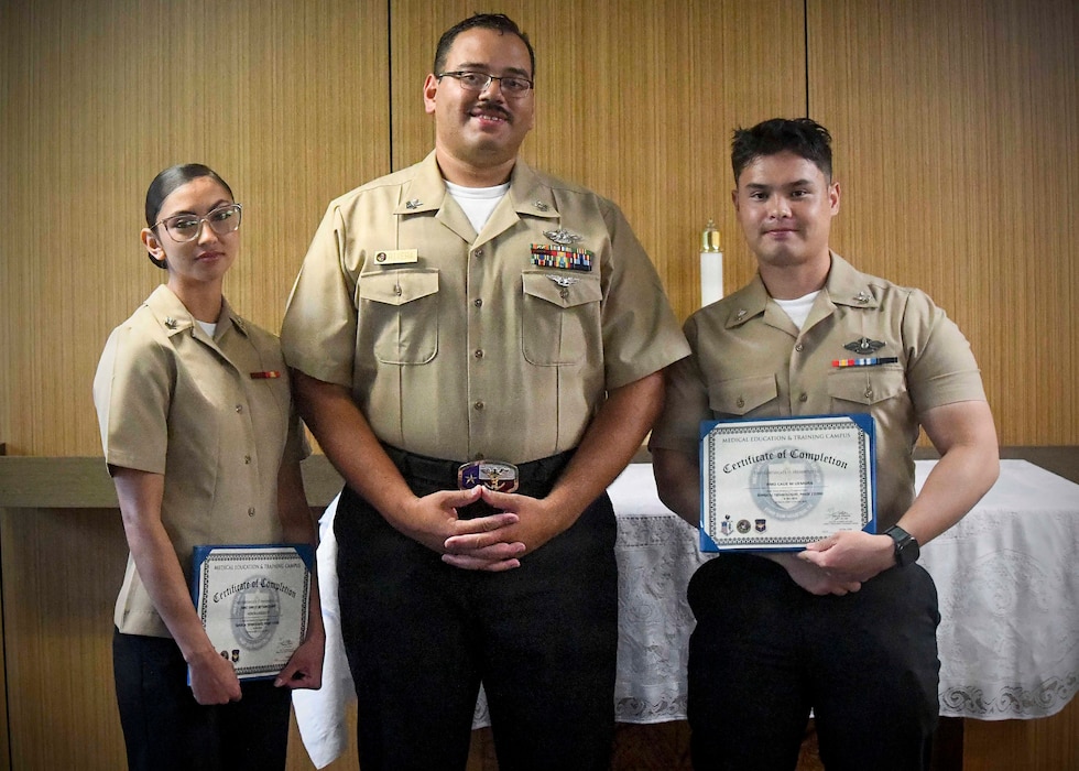 Navy Medicine Training Support Center (NMTSC), Detachment Camp Lejeune held a ceremony on July 23, 2026, honoring its latest students from the Surgical Technology Program (Phase II). Hospital Corpsman Second Class Emely Betancourt and Hospital Corpsman Second Class Caue Uemura received their certificates of completion, presented by Hospital Corpsmen First Class Christopher River, leading petty officer for NMTSC Detachment Camp Lejeune. 
Pictured left to right: Hospital Corpsman Second Class Emely Betancourt, Hospital Corpsman First Class Christopher Rivera, and Hospital Corpsman Second Class Caue Uemura.