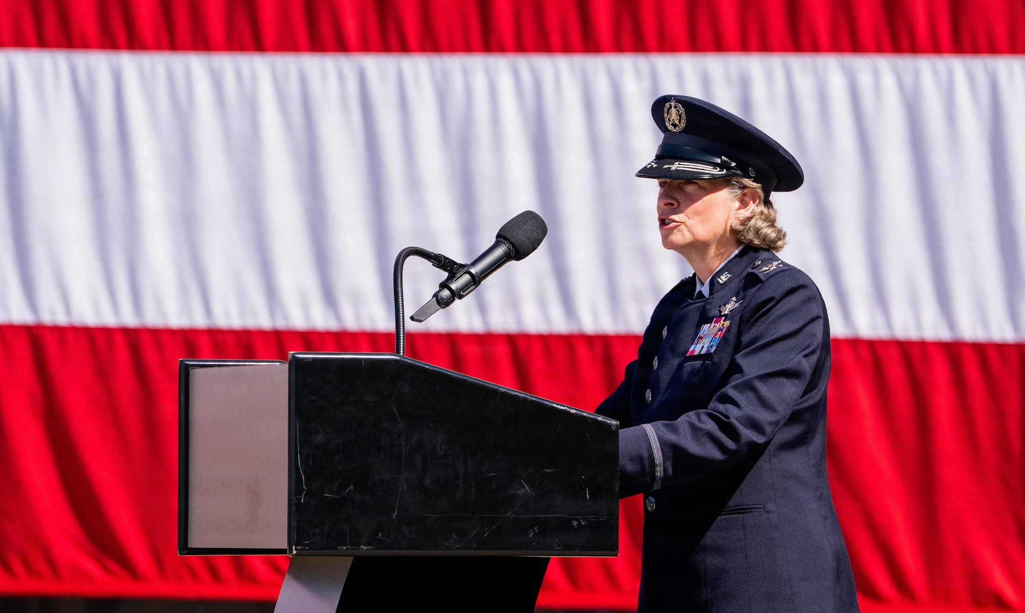Change of command ceremony. People in uniform, & flags.