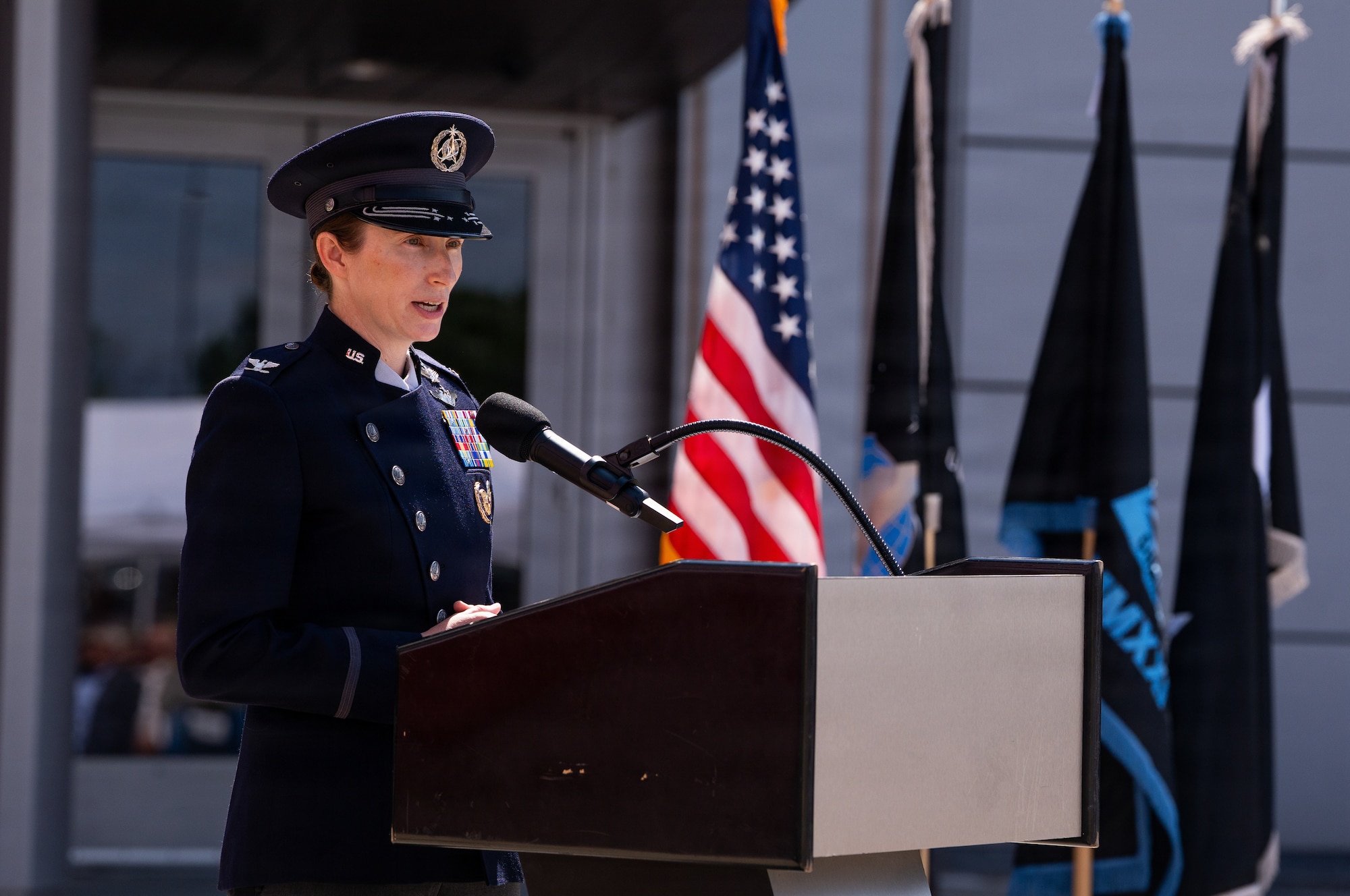 Change of command ceremony. People in uniform, & flags.
