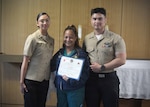 Navy Medicine Training Support Center (NMTSC), Detachment Camp Lejeune held a ceremony on July 23, 2026, honoring its latest students from the Surgical Technology Program (Phase II) graduates Hospital Corpsman Second Class Emely Betancourt (left) and Hospital Corpsman Second Class Caue Uemura (right) present civilian surgical technologist Azucena Naval with Naval Medical Center Camp Lejeune the “Golden Scalpel Award.” The award honors the preceptor the surgical technology students feel most assisted with their development in the course.