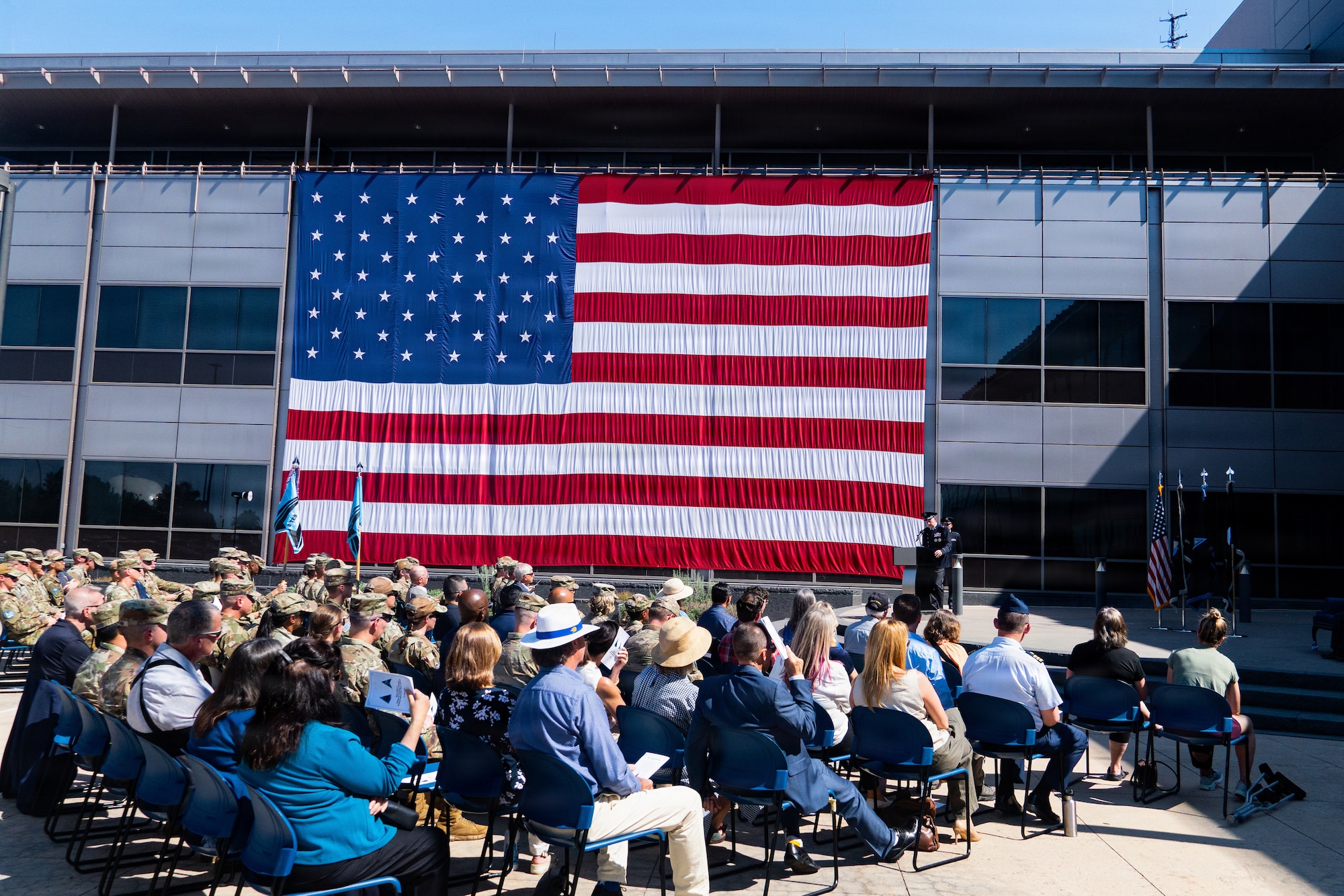 Change of command ceremony. People in uniform, & flags.