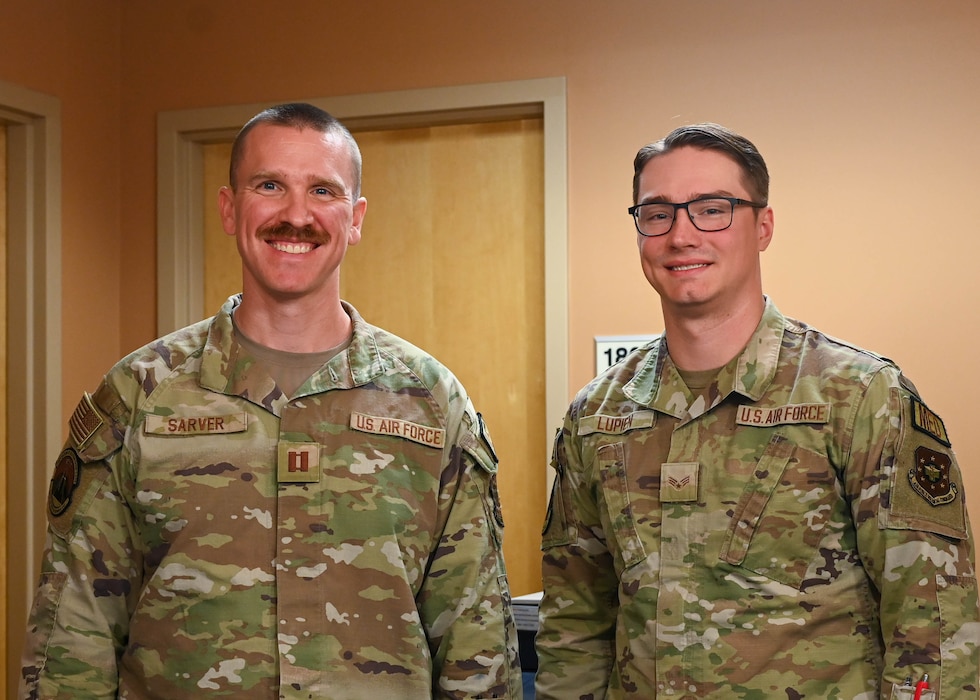 From left, U.S. Air Force Capt. Max Sarver, Luke Medical Group Operational Medical Readiness Squadron optometry element chief, and Senior Airman Wyatt Lupien, 56th Operational Medical Readiness Squadron optometry technician, pose for a portrait at Luke Air Force Base, Arizona, July 29, 2026. Sarver and Lupien performed CPR and utilized an automated external defibrillator to save the life of a veteran using their fundamental medical training and basic life support skills.