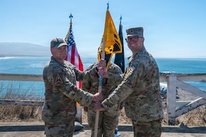 Two people stand and hold a flag