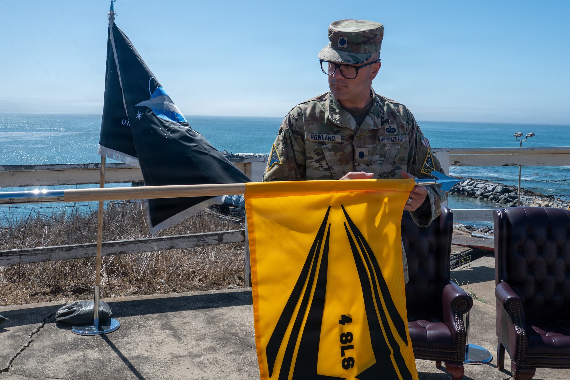 A person unveils a flag