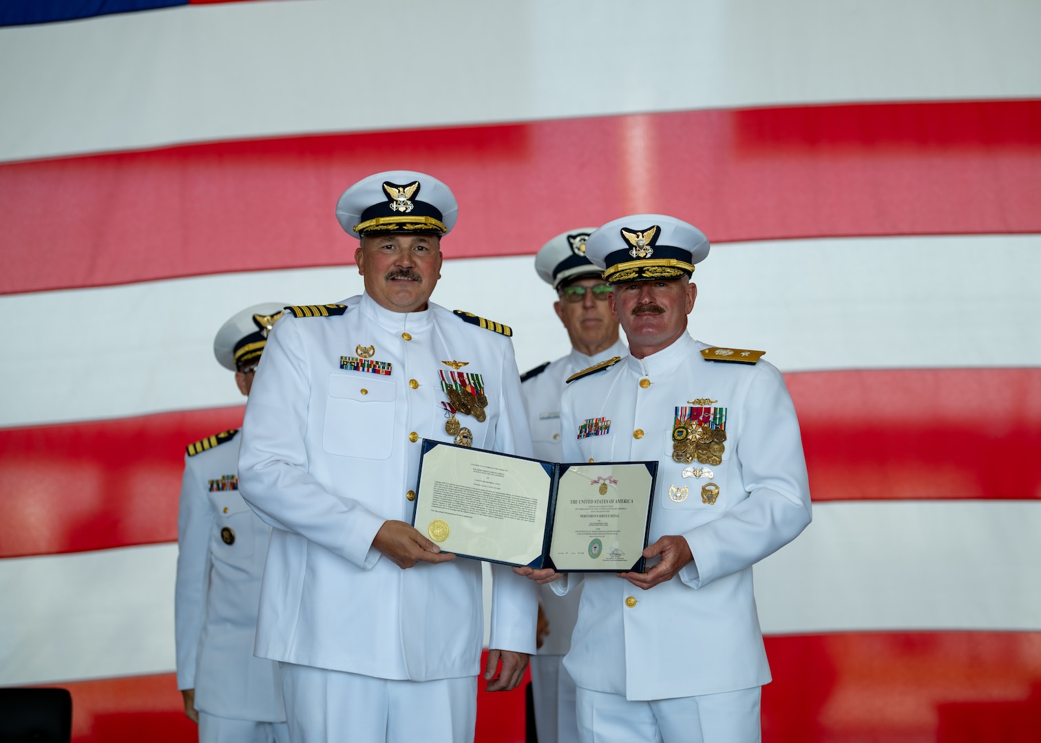 U.S. Coast Guard Capt. Bradford Apitz receives the Meritorious Service Medal from Rear Adm. Jeffery Novak, the Coast Guard Southwest District commander, during a change of command ceremony at Air Station Sacramento, McClellan Park, California, July 31, 2026. During the ceremony, Coast Guard Capt. Patrick Dill was formally recognized as the new air station commander. (U.S. Coast Guard photo by Petty Officer 3rd Class Kenneth Wiese)