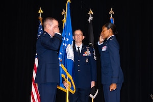 U.S. Air Force Col. Lacresha A. Merkle (right) renders her first salute to Brig. Gen. Jeffrey W. Nelson (left), outgoing commander of the Air Force Recruiting Service (AFRS), during an assumption of command ceremony at Joint Base San Antonio-Randolph, Texas, July 30, 2026. Chief Master Sgt. Jake Fason (center), the new AFRS command chief, served as the guidon bearer for the ceremony, where Merkle formally took leadership of the service from Nelson. (U.S. Air Force photo by A1C Amanda Yastrzab)