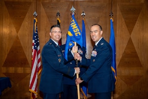 U.S. Air Force Maj. Gen. Thomas P. Sherman, Air Force Installation and Mission Support Center commander, passes the guidon to U.S. Air Force Col. Richard Martin, AFIMSC Det. 4 incoming commander, during a change of command ceremony at Ramstein Air Base, Germany, July 31, 2026.