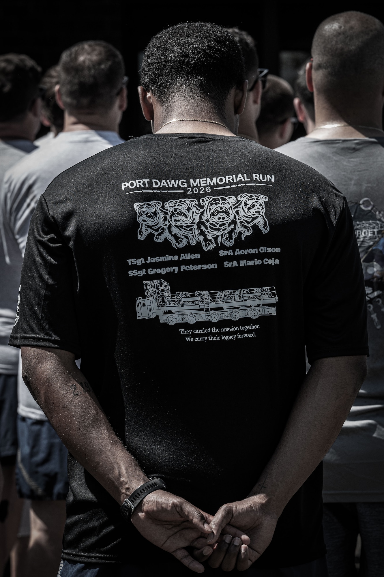 A U.S. Air Force member wears a shirt displaying the names of fallen aerial port Airmen, known as Port Dawgs, during the 13th annual Port Dawg memorial run at Joint Base McGuire-Dix-Lakehurst, N.J., May 28, 2026.