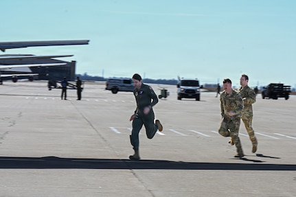 Team McConnell members rush from an alert van to an aircraft during a nuclear operational response exercise at McConnell Air Force Base, Kansas, Feb. 7, 2026. Members ran to board the aircraft to simulate the time sensitive nature of a potential attack. (U.S. Air Force photo by Senior Airman Amelio Brown)