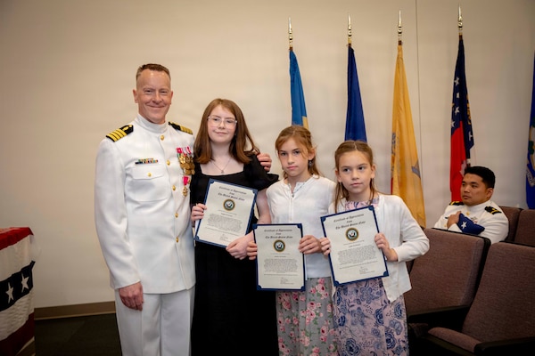 Naval Medical Forces Atlantic Command Deputy Commander, Capt. Chad McKenzie,  a native of Bellefontaine, Ohio, presents his family with certificates of appreciation during his retirement ceremony on board Naval Support Activity (NSA) Hampton Roads - Portsmouth Annex, Portsmouth, Virginia, May 29, 2026. McKenzie served the Navy for nearly 30 years of dedicated service across 16 commands and helped advance Navy Medicine’s operational readiness and expeditionary medical capabilities in support of Fleet, Marine Corps, and joint force requirements. (U.S. Navy photo by Mass Communication Specialist 2nd Class Levi Decker)