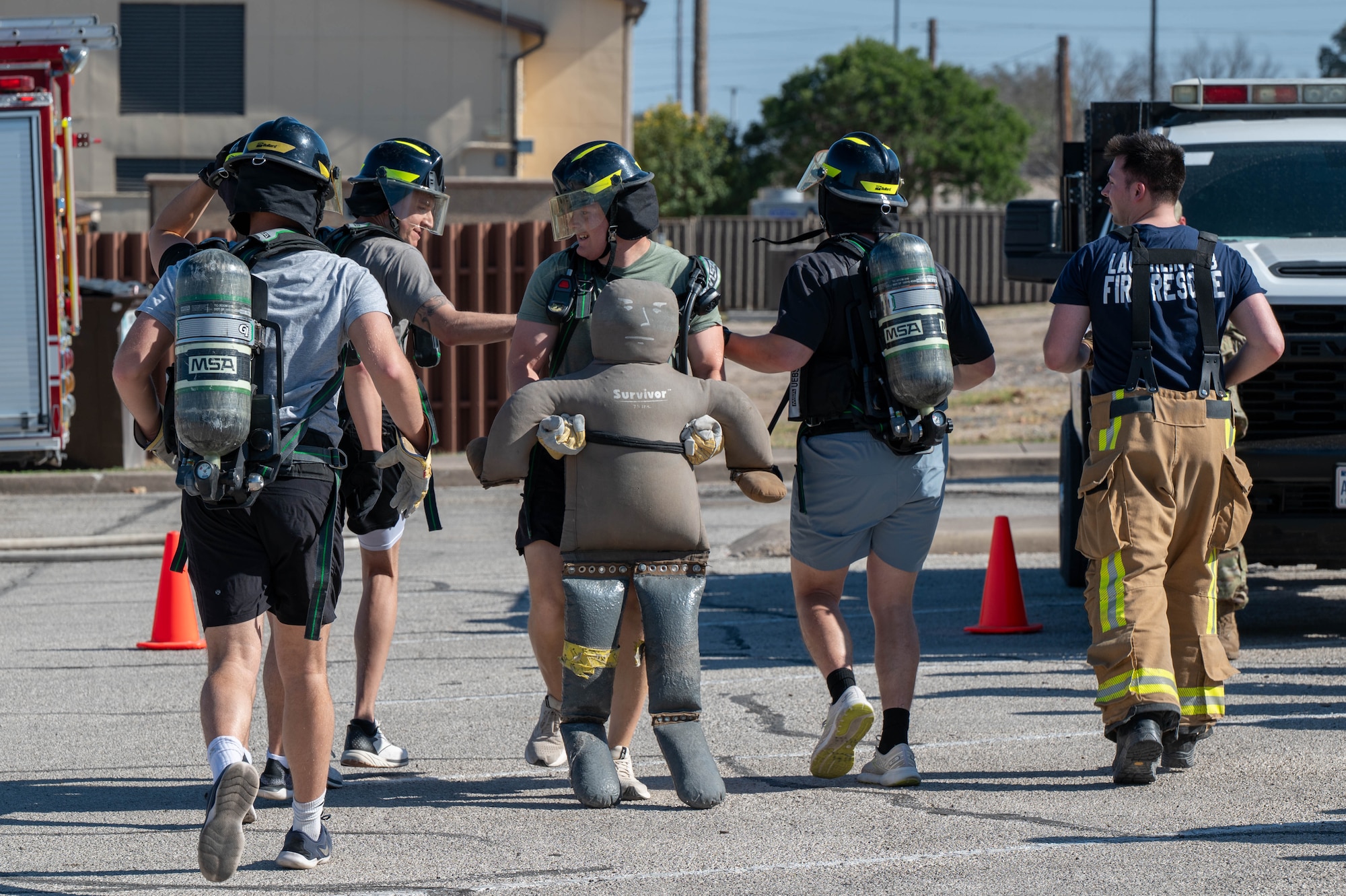 Participants in one the Warrior Action Team’s professional development events run while carrying a dummy during the firefighter challenge at Laughlin Air Force Base, Texas, Feb. 27, 2026. The goal of the WAT acts as the central hub for continuity, resource alignment, and deliberate messaging, and strives to ensure every Airman is empowered to win. (U.S. Air Force photo by Senior Airman Jarrett Smith)