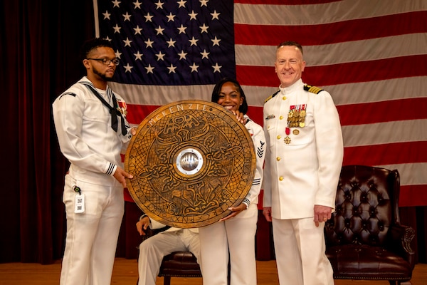 Naval Medical Forces Atlantic (NMFL) Sailors present a gift from NMFL’s wardroom to Capt. Chad McKenzie, deputy commander, NMFL and a native of Bellefontaine, Ohio, during his retirement ceremony on board Naval Support Activity (NSA) Hampton Roads - Portsmouth Annex, Portsmouth, Virginia, May 29, 2026. McKenzie served the Navy for nearly 30 years of dedicated service across 16 commands and helped advance Navy Medicine’s operational readiness and expeditionary medical capabilities in support of Fleet, Marine Corps, and joint force requirements. (U.S. Navy photo by Mass Communication Specialist 2nd Class Levi Decker)