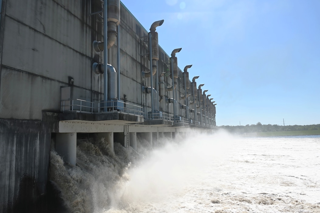 Water discharged through pumps at a massive structure.