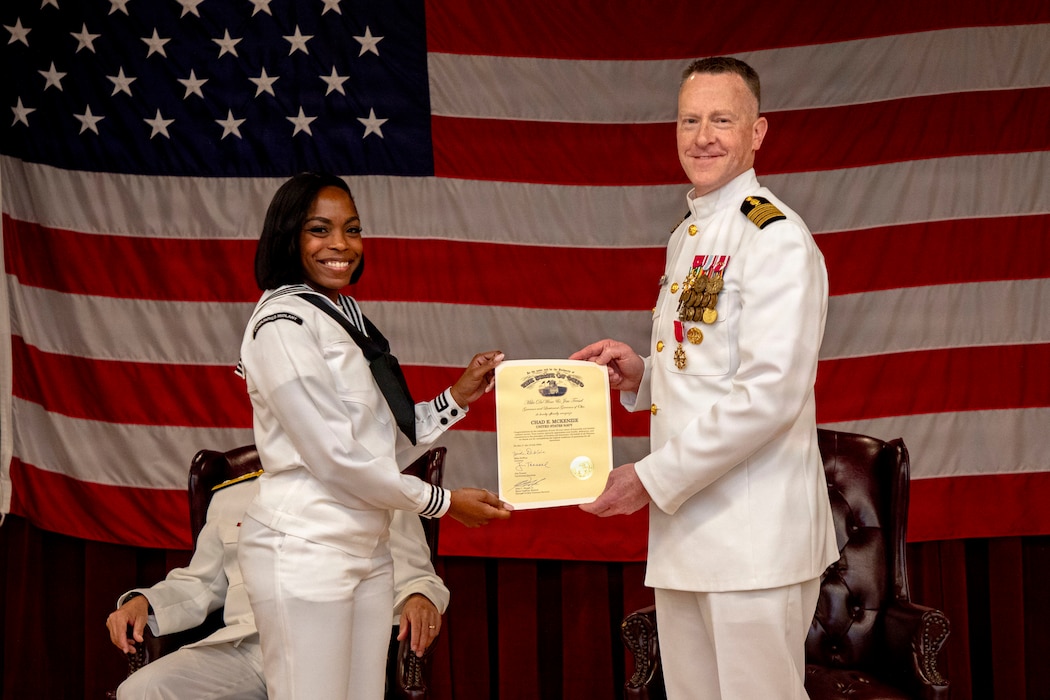 Yeoman 1st Class Brande McLane, assigned to Naval Medical Forces Atlantic (NMFL), presents a Governor's Certificate of Appreciation to Capt. Chad McKenzie,  deputy commander, NMFL and a native of Bellefontaine, Ohio, during his retirement ceremony on board Naval Support Activity (NSA) Hampton Roads - Portsmouth Annex, Portsmouth, Virginia, May 29, 2026. McKenzie served the Navy for nearly 30 years of dedicated service across 16 commands and helped advance Navy Medicine’s operational readiness and expeditionary medical capabilities in support of Fleet, Marine Corps, and joint force requirements. (U.S. Navy photo by Mass Communication Specialist 2nd Class Levi Decker)