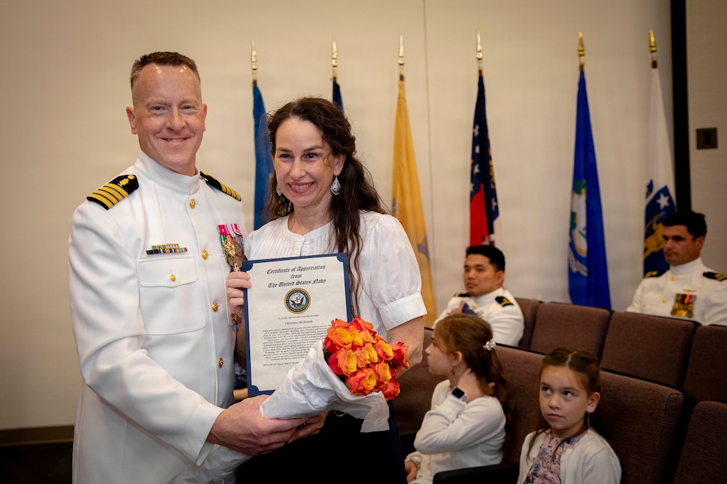 Naval Medical Forces Atlantic Command Deputy Commander, Capt. Chad McKenzie,  a native of Bellefontaine, Ohio, presents his family with certificates of appreciation during his retirement ceremony on board Naval Support Activity (NSA) Hampton Roads - Portsmouth Annex, Portsmouth, Virginia, May 29, 2026. McKenzie served the Navy for nearly 30 years of dedicated service across 16 commands and helped advance Navy Medicine’s operational readiness and expeditionary medical capabilities in support of Fleet, Marine Corps, and joint force requirements. (U.S. Navy photo by Mass Communication Specialist 2nd Class Levi Decker)