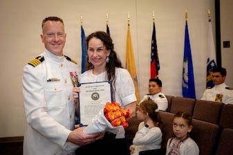 Naval Medical Forces Atlantic Command Deputy Commander, Capt. Chad McKenzie,  a native of Bellefontaine, Ohio, presents his family with certificates of appreciation during his retirement ceremony on board Naval Support Activity (NSA) Hampton Roads - Portsmouth Annex, Portsmouth, Virginia, May 29, 2026. McKenzie served the Navy for nearly 30 years of dedicated service across 16 commands and helped advance Navy Medicine’s operational readiness and expeditionary medical capabilities in support of Fleet, Marine Corps, and joint force requirements. (U.S. Navy photo by Mass Communication Specialist 2nd Class Levi Decker)