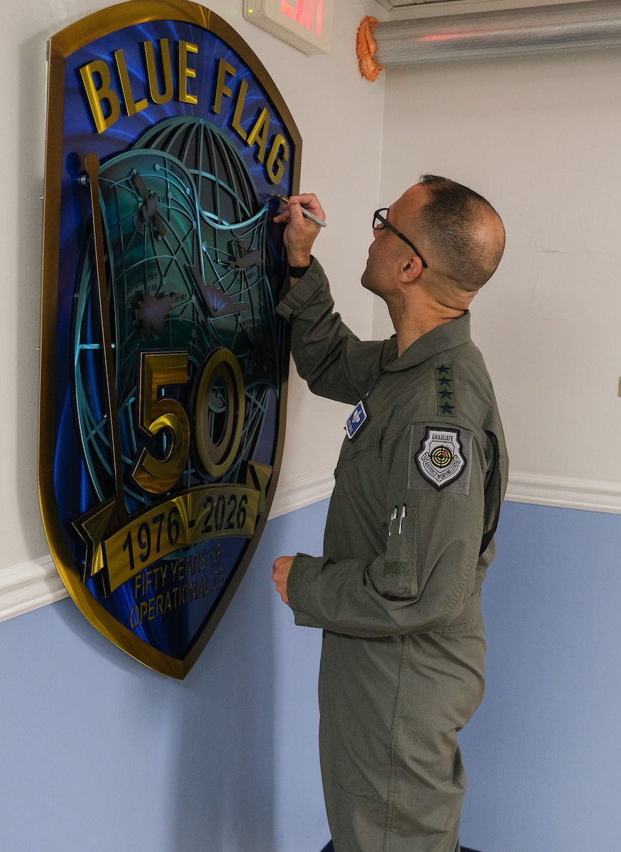USAF Airman signs Blue Flag 50th Anniversary metal art