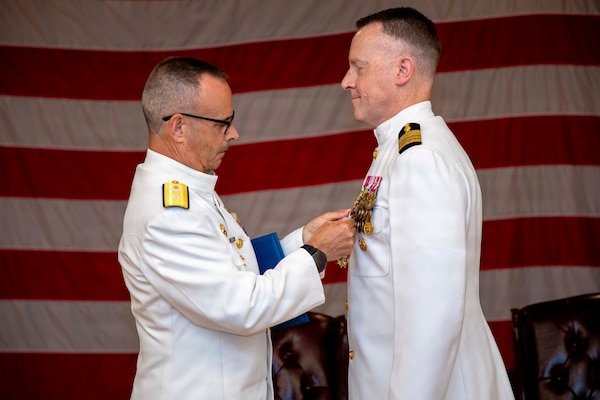Rear Adm. Robert Hawkins, commander, Naval Medical Forces Atlantic (NMFL), presents a Legion of Merit to Capt. Chad McKenzie, deputy commander, NMFL and a native of Bellefontaine, Ohio, during his retirement ceremony on board Naval Support Activity (NSA) Hampton Roads - Portsmouth Annex, Portsmouth, Virginia, May 29, 2026. McKenzie served the Navy for nearly 30 years of dedicated service across 16 commands and helped advance Navy Medicine’s operational readiness and expeditionary medical capabilities in support of Fleet, Marine Corps, and joint force requirements.  (U.S. Navy photo by Mass Communication Specialist 2nd Class Levi Decker)