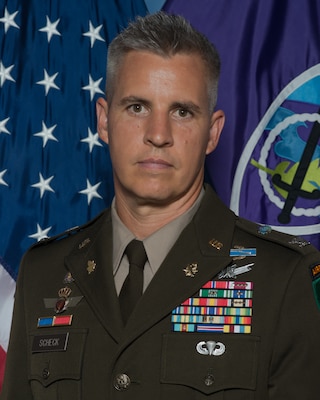Col. Charles J. Scheck, commander, 350th Civil Affairs Command in his AGSU in front of command flags