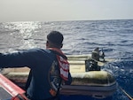 A Coast Guard Boat Forces Unit U.S. Virgin Islands 33-Special Purpose Craft-Law Enforcement crew member inspects an overturned dinghy following the rescue of a boater south of St. Thomas, U.S. Virgin Islands, May 31, 2026.  The survivor informed being the sole passenger aboard the 45-foot catamaran, Abundance, which reportedly caught fire and sank moments earlier.  St John Rescue also arrived on scene, while the survivor was transferred to a Virgin Islands Fire and Emergency Medical Services crew, who transported him to Charlotte Amalie in St. Thomas. (U.S. Coast Guard photo)