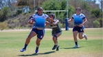 Petty Officer 2nd Class Ra’Shaun Coker surges past a Marine defender after gaining possession during the 6th annual Armed Forces Women’s Rugby Championship in Chula Vista, California, Sept., 2025. Coker is known for her dedication and leadership on and off the field.