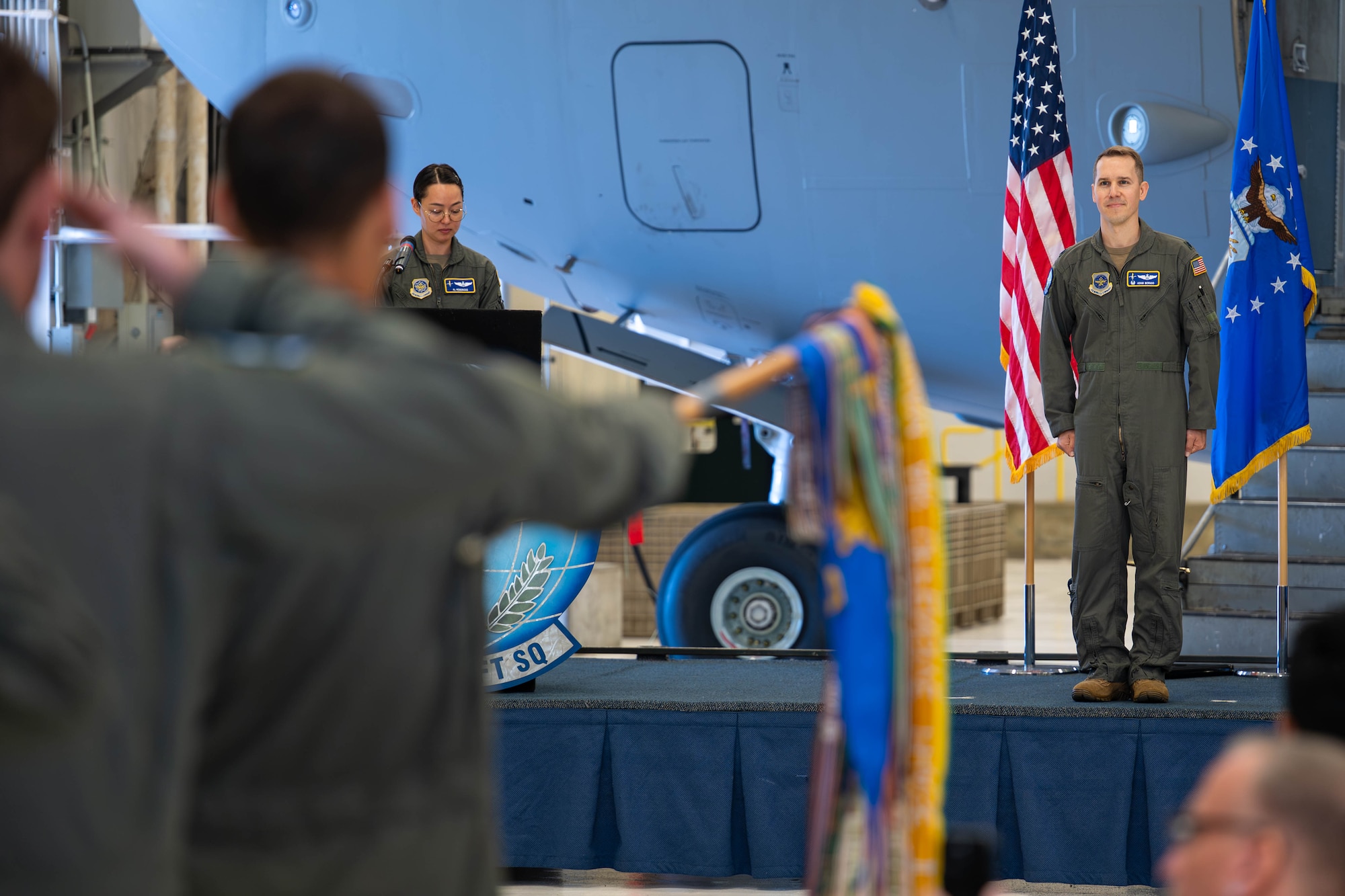 People salute a man on stage.