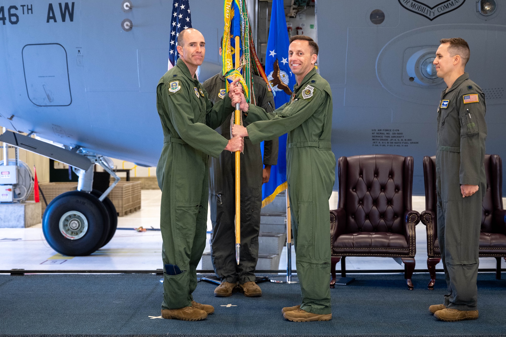 Two men stand holding a flag.