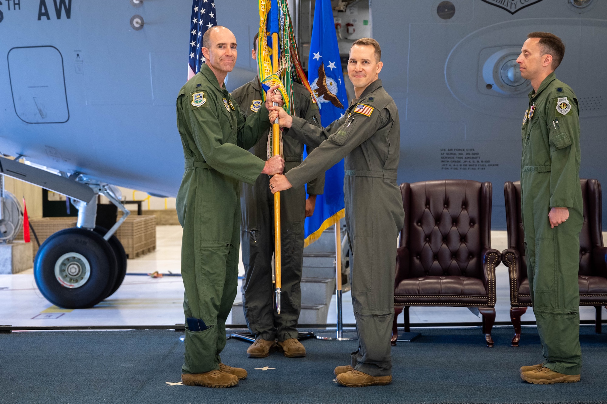 Two men stand holding a flag.