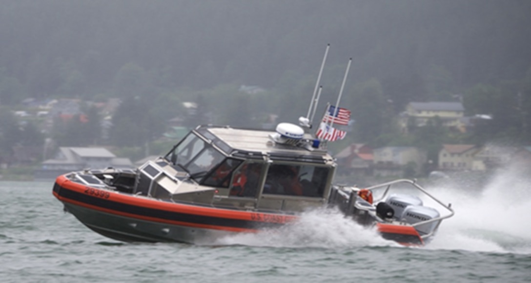 A small Coast Guard boat navigates water at high speed.