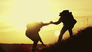 silhouette-two-people-working-in-team-mountain-rock-climbing-helping-hand-friend
