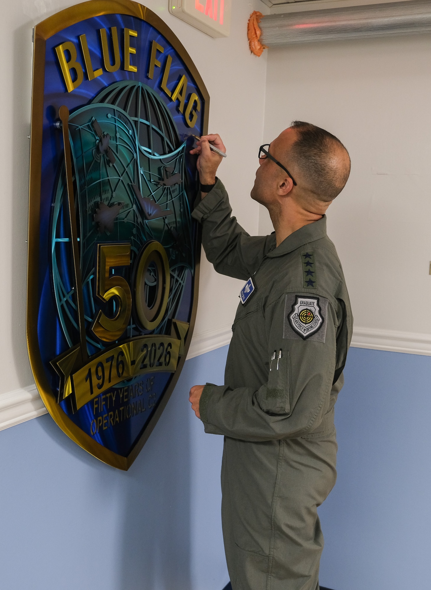 USAF Airman signs Blue Flag 50th Anniversary metal art