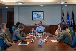 a group of people sit at a table and have a conversation