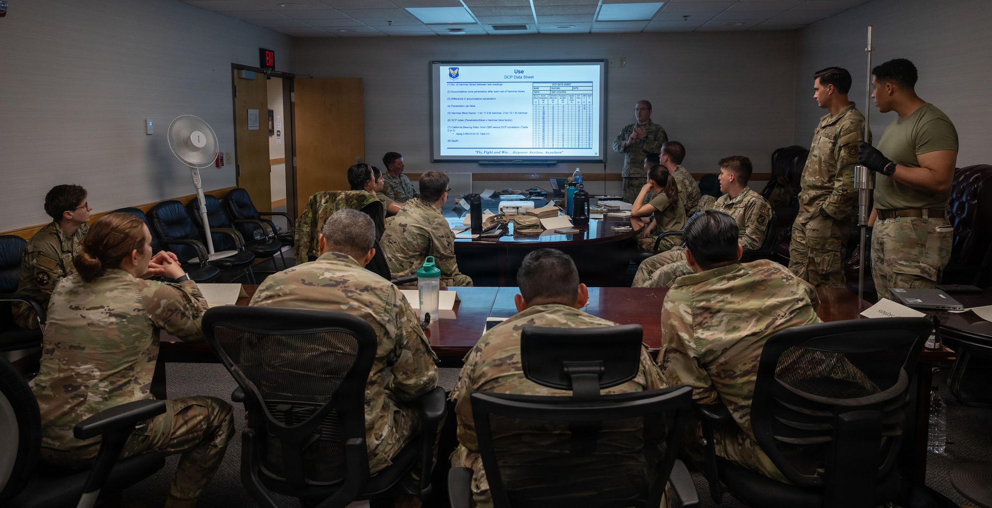 Airmen sit in a classroom.