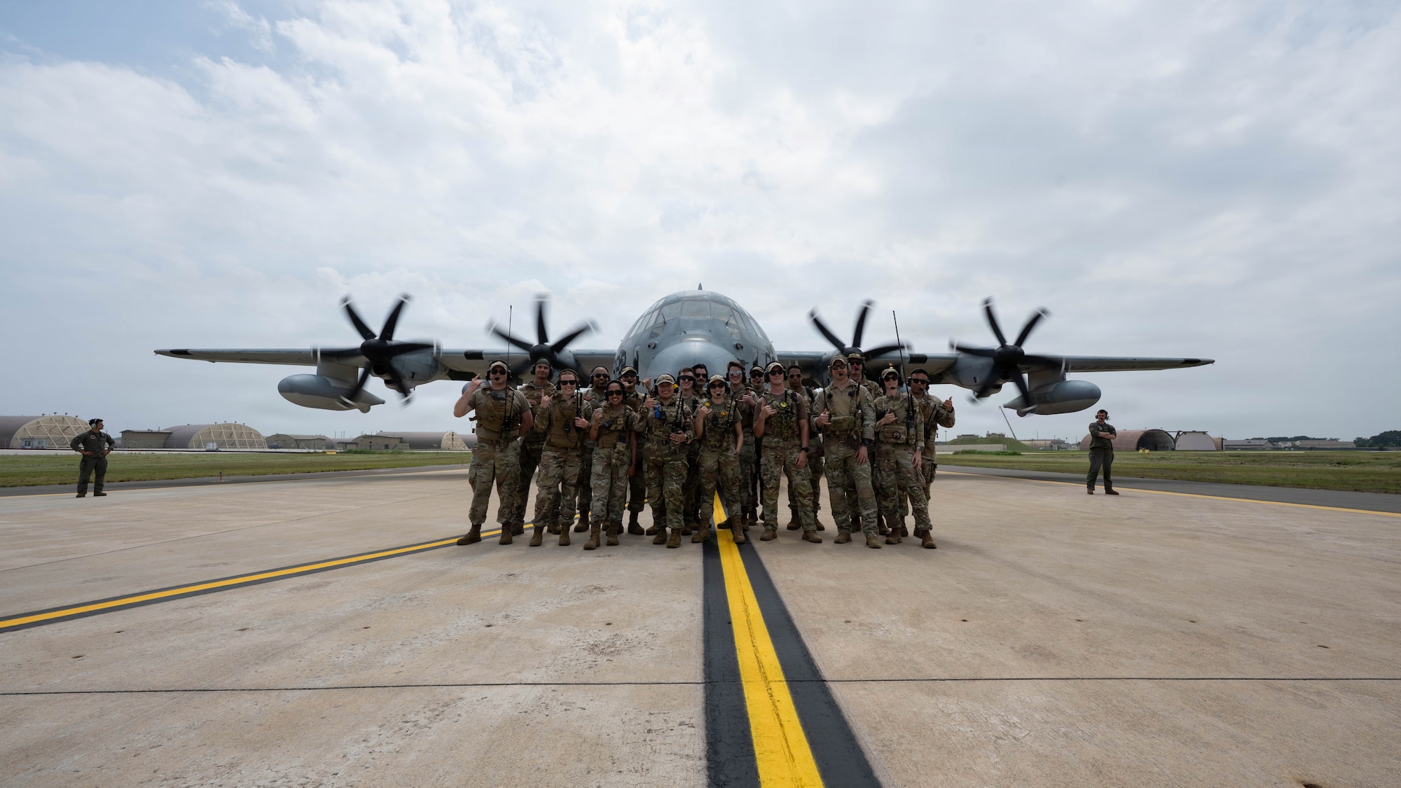 Airman pose for group photo in front of aircraft.