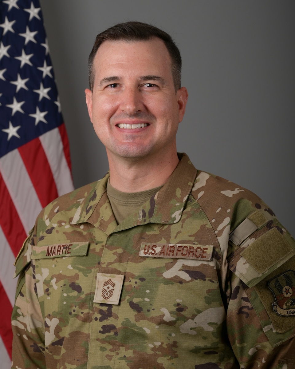 Official photo of Chief Master Sgt. David P. Martie in front of a U.S. flag