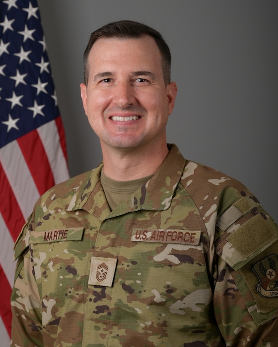 Official photo of Chief Master Sgt. David P. Martie in front of a U.S. flag
