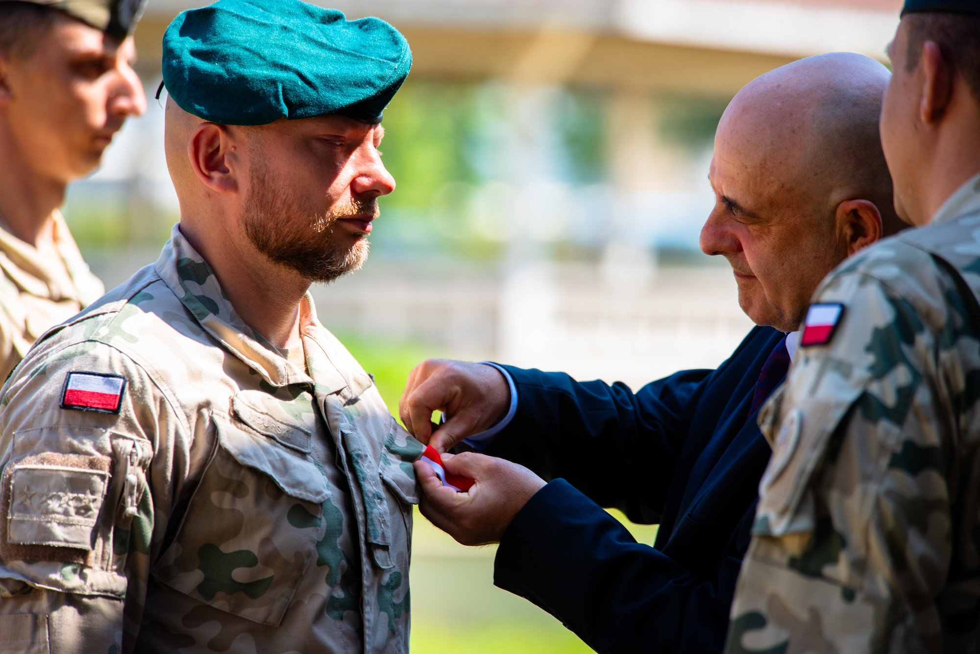 Polish Ambassador pins a medal onto a Polish military member