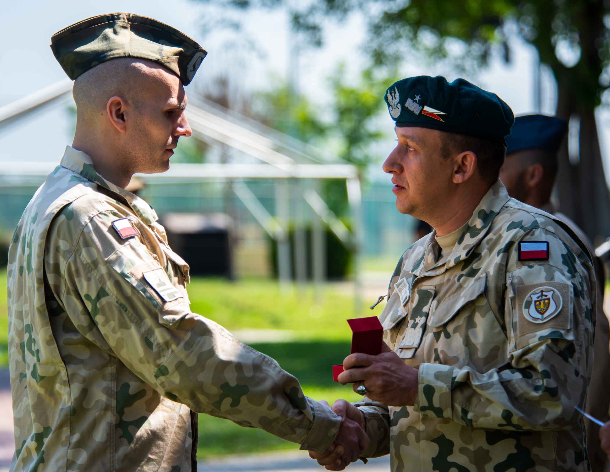 Polish Brig. Gen. Jaroslaw Chojnacki presents an award to a Polish military member