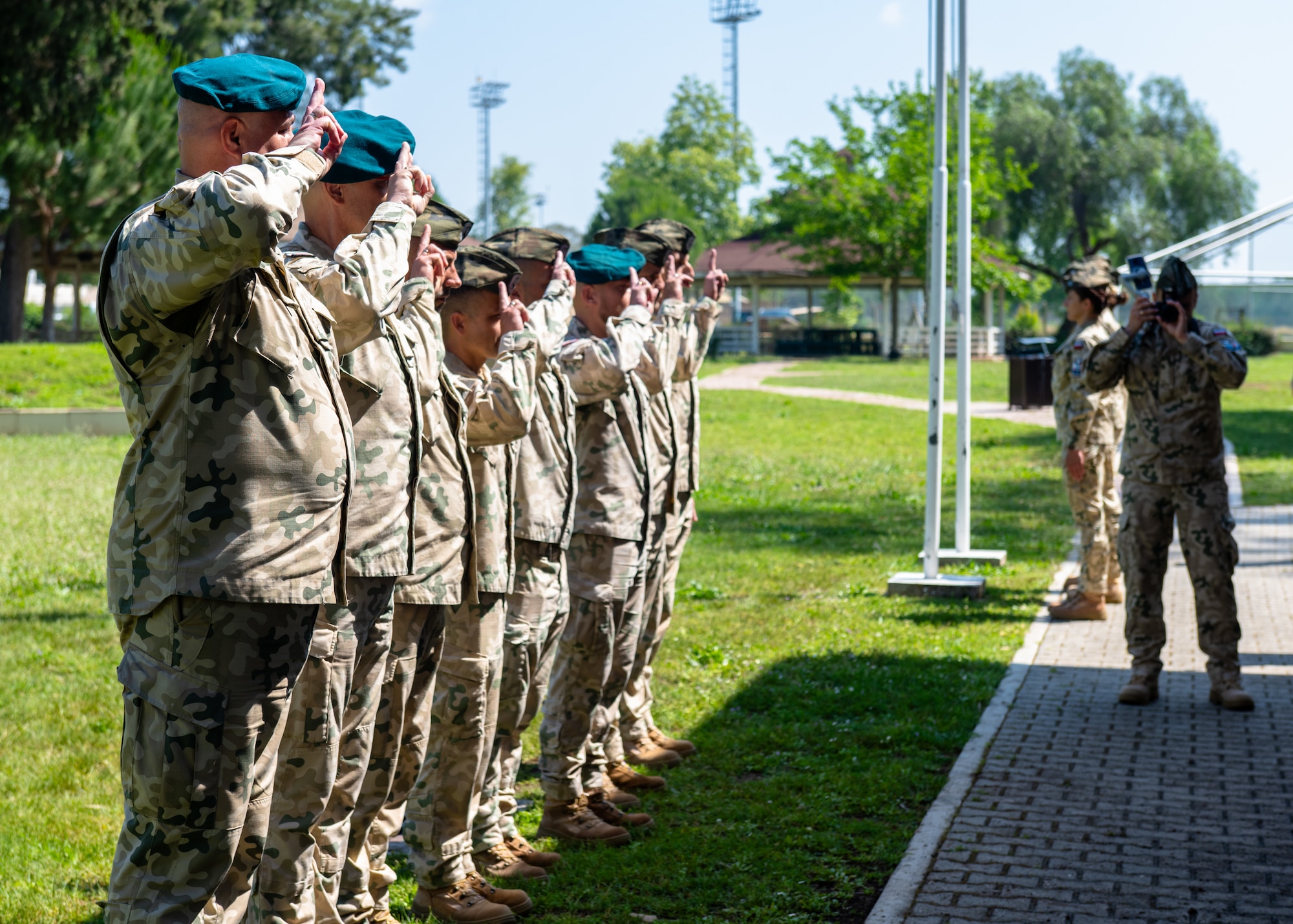 Polish military members render a salute