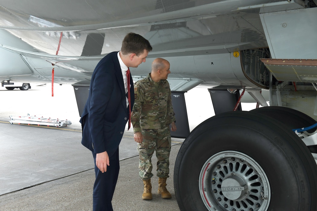 Airman and Government official stand in front of a RC-135 Rivet Joint aircraft at Offutt Air Force Base, Neb.