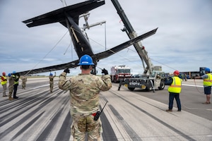 Members of Vance Air Force Base, Oklahoma's Crash Damaged Disabled Aircraft Recovery team remove a T-6A Texan II from McConnell Air Force Base, Kansas's flightline May 20,2026. The T-6A, from Vance AFB, performed an emergency belly-landing due to a landing gear malfunction, avoiding injury to both aircrew members. (U.S. Air Force photo by Airman 1st Class Tavian Sims)